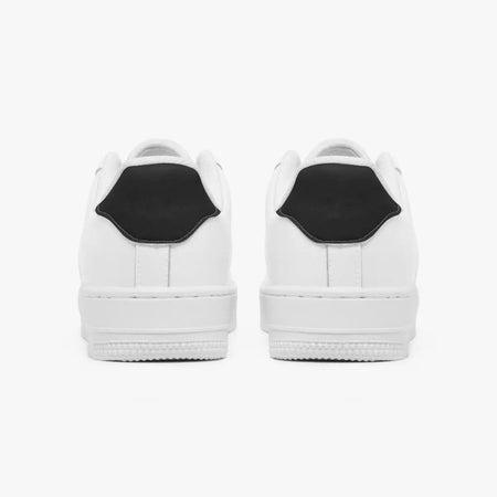 Rear view of white sneakers displaying contrasting black heel tabs, white leather collars, and textured white rubber platform midsoles.