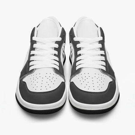 Front-facing top angle of black and white low-top sneakers displaying clean white laces, black eyestays, and perforated white toe boxes.