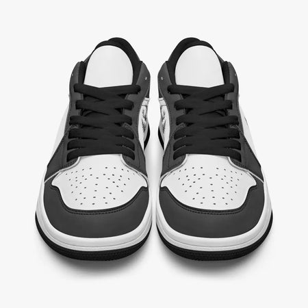 Front-facing top angle of black and white low-top sneakers showcasing black laces, black eyestays, and perforated white toe boxes.