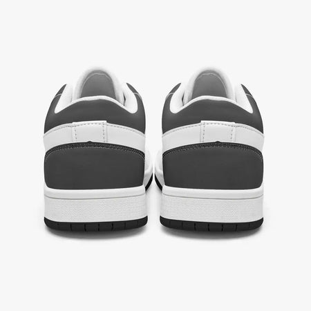Rear view of black and white sneakers displaying dark charcoal heel overlays, white leather collar panels, white interior linings, and clean white midsoles above black outsoles.