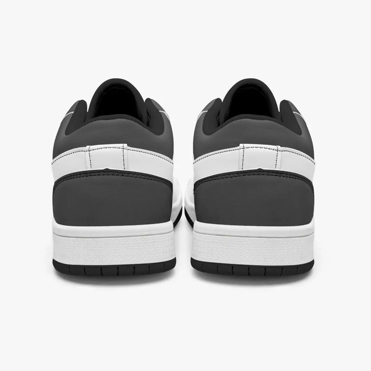 Rear view of black and white sneakers showing dark charcoal heel overlays, white leather collar panels, black interior collar lining, and white midsoles above black outsoles.