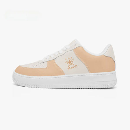 A low-top sneaker in a light peach and white colorway, featuring a white rubber sole, white laces, and a gold star logo with the text 'Starzy' on the side panel.