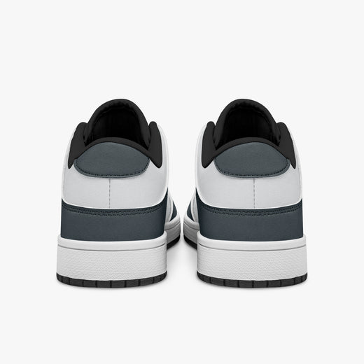 Rear view of slate blue-grey and white sneakers showing slate blue-grey heel overlays, white leather collars, and black interior collar lining above white midsoles.