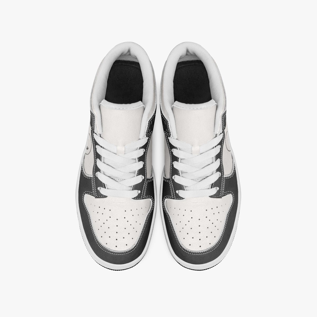 Overhead view of black and white sneakers showing clean white laces, white padded collar lining, and perforated white leather toe boxes.