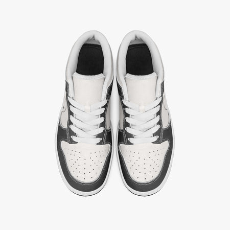 Overhead view of black and white sneakers showing clean white laces, white padded collar lining, and perforated white leather toe boxes.