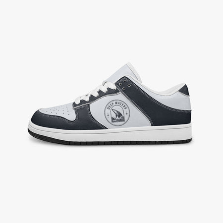Side profile view of the left sneaker highlighting the dark navy leather overlays, ocean whale illustration, white laces, white interior lining, and contrasting black outsole facing right.