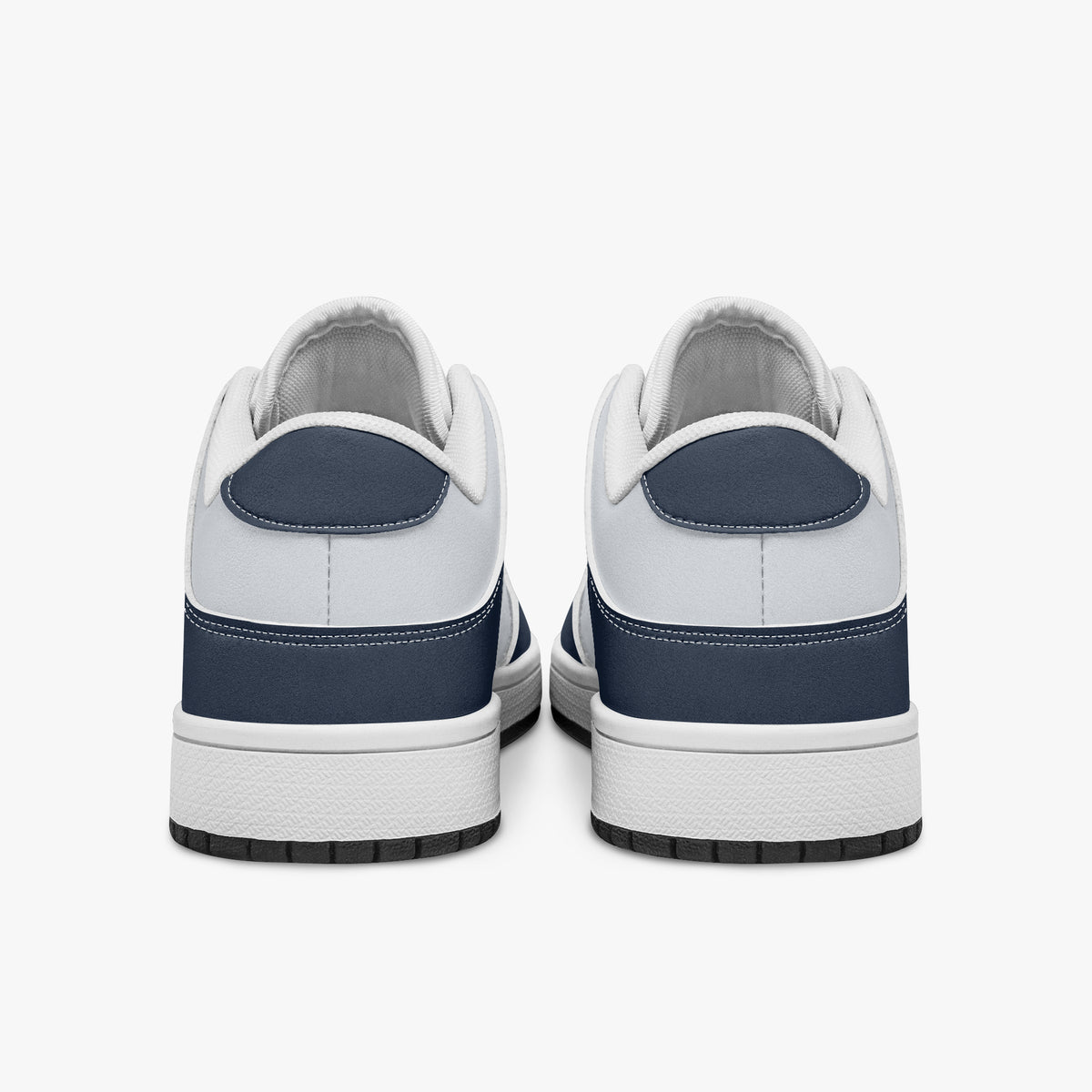 Rear view of the sneakers displaying navy blue heel overlays, white leather collar lining, and two-tone white and black rubber outsoles.