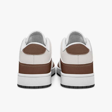 Rear view of brown and cream sneakers displaying coffee brown heel overlays, off-white leather collar panels, and two-tone white and black rubber outsoles.