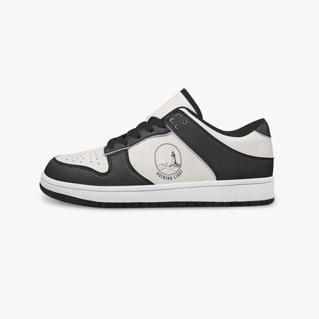 Side profile view of the left sneaker highlighting the black leather panels, lighthouse emblem, black interior lining, and flat rubber sole facing right.