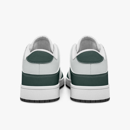 Rear view of dark green and white sneakers displaying deep green heel overlays, white leather collar panels, and two-tone white and black rubber outsoles.