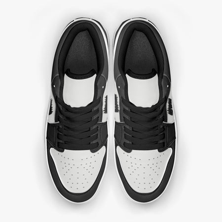 Overhead view of black and white sneakers displaying black laces, black padded collar lining, and perforated white leather toe boxes.