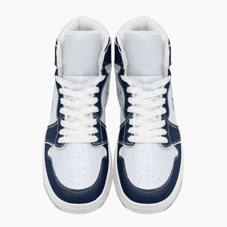 Overhead top-down view of high-top sneakers highlighting navy blue eyestays, white lacing, and perforated white leather vamps.