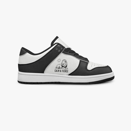 Side profile view of the right sneaker showcasing the black and white color blocking, "CALM & FIERCE" lion graphic, black laces, and black rubber outsole facing right.