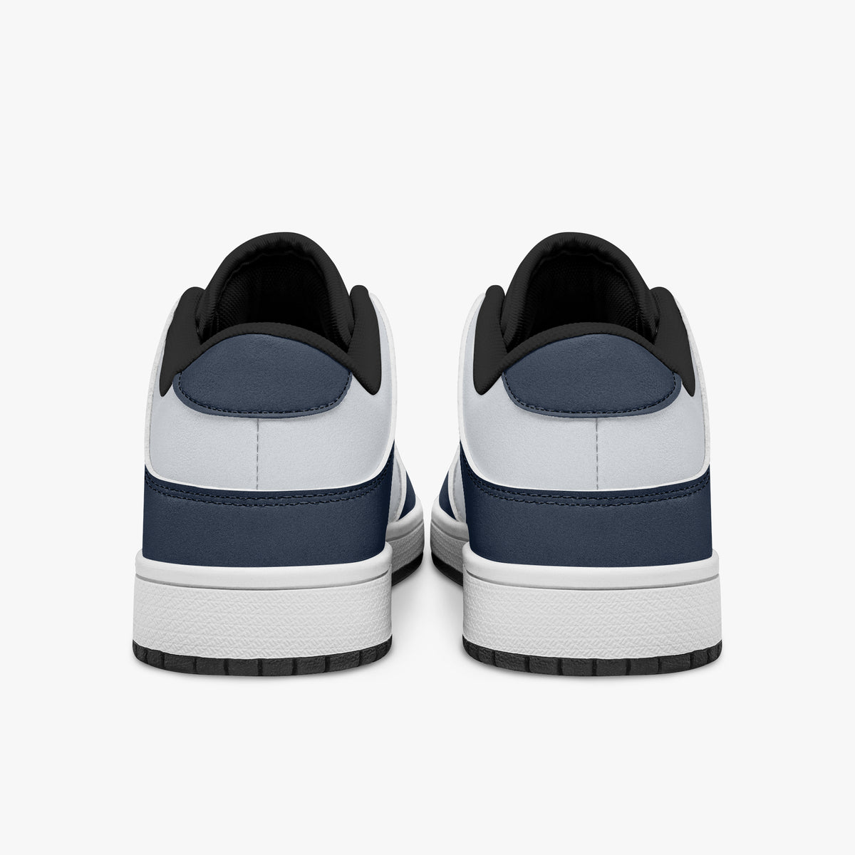 Rear view of navy blue and white sneakers displaying dark blue heel overlays, white leather collars, and two-tone white and black rubber outsoles.