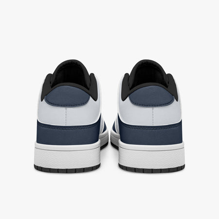 Rear view of navy blue and white sneakers displaying dark blue heel overlays, white leather collars, and two-tone white and black rubber outsoles.