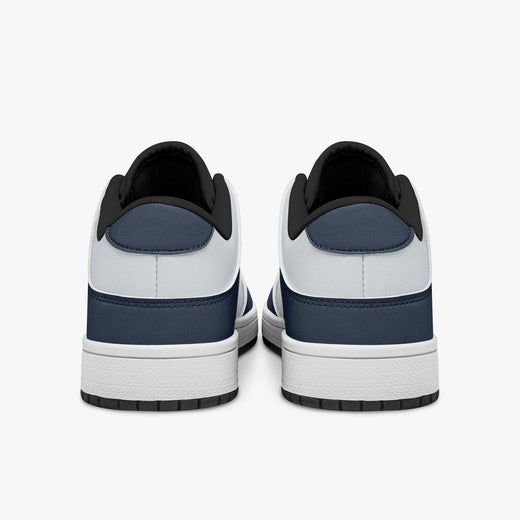 Rear view of navy blue and white sneakers displaying dark blue heel overlays, white leather collars, and two-tone white and black rubber outsoles.