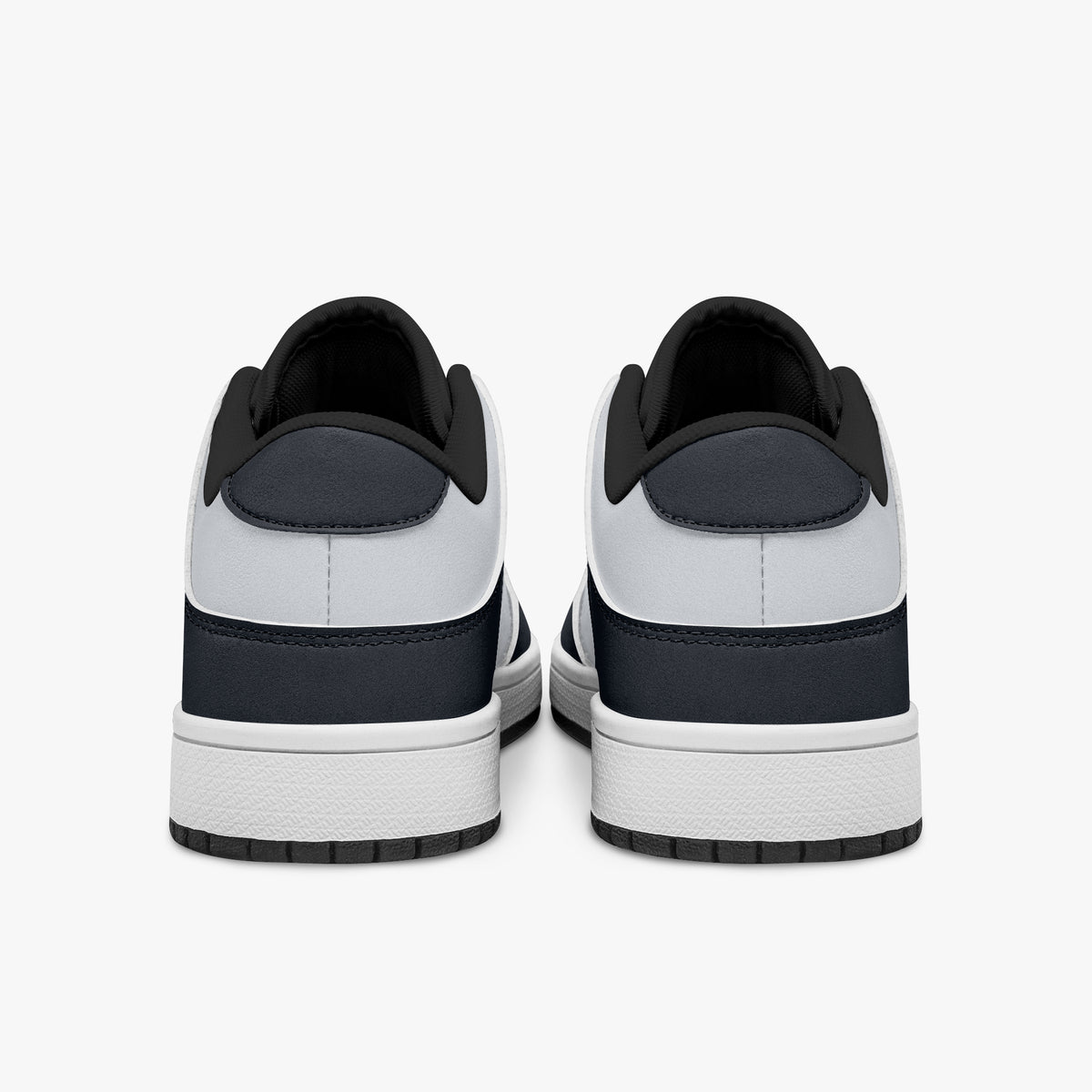 Rear view of navy and white sneakers showing dark navy heel overlays, white leather collars, and black interior collar lining above white midsoles.