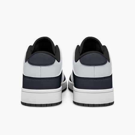 Rear view of navy and white sneakers showing dark navy heel overlays, white leather collars, and black interior collar lining above white midsoles.