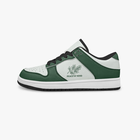 Side profile view of the left sneaker highlighting the green leather panels, botanical emblem, black interior lining, and flat rubber sole facing right.