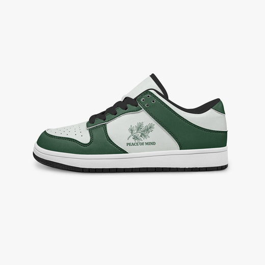 Side profile view of the left sneaker highlighting the green leather panels, botanical emblem, black interior lining, and flat rubber sole facing right.