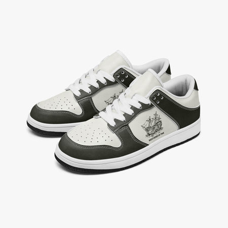 Angled three-quarter view of low-top sneakers in charcoal olive-grey and off-white leather, featuring a sailing vessel graphic with "WEATHERED BY TIME", white laces, and a white inner lining.