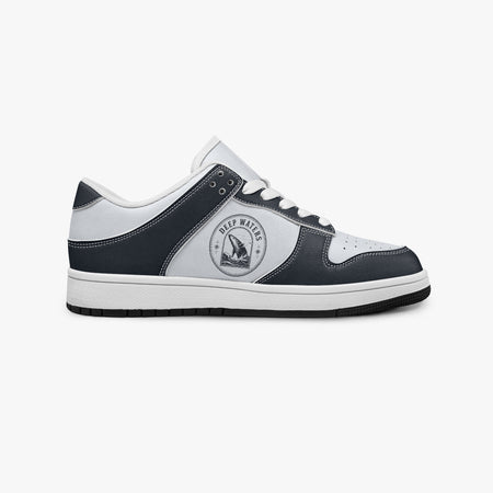 Side profile view of the right sneaker in navy and white leather, showcasing the "DEEP WATERS" whale crest, white eyelet lacing, and flat rubber sole facing right.