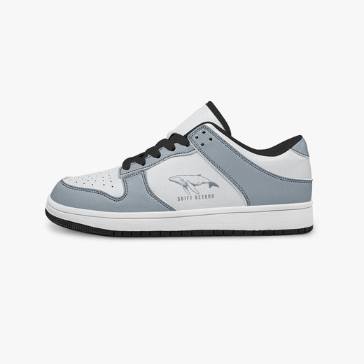 Side profile view of the left sneaker highlighting the slate blue-grey leather panels, whale emblem, black interior lining, and flat rubber sole facing right.