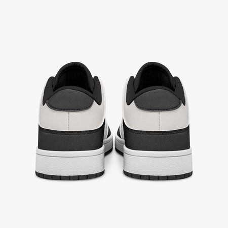 Rear view of black and white sneakers showing dark charcoal heel overlays, white leather collars, and black interior collar lining above white midsoles.