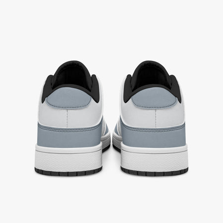 Rear view of slate blue-grey and white sneakers showing slate blue-grey heel overlays, white leather collars, and black interior collar lining above white midsoles.