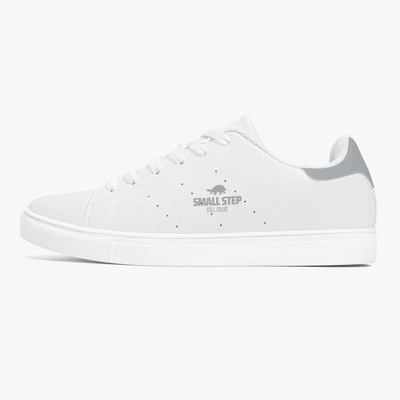 A white low-top sneaker with a gray heel accent and a gray 'SMALL STEP by CUBAN' logo printed on the side, shown against a light gray background.
