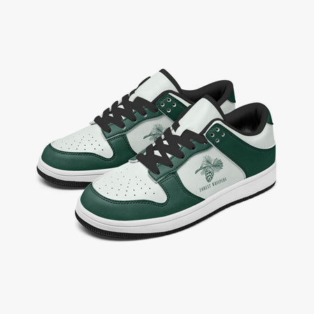 Angled three-quarter view of low-top sneakers in forest green and white leather, featuring a pine cone and branch graphic with "FOREST WHISPERS", black laces, and a black inner lining.